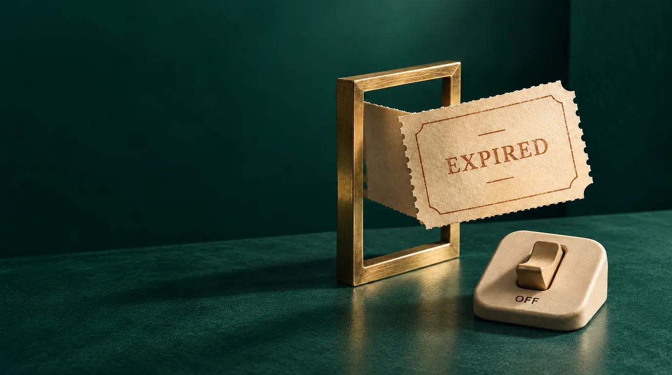 A coupon stamped EXPIRED sliding out of a brass frame next to a switch set to OFF, on a dark green desk